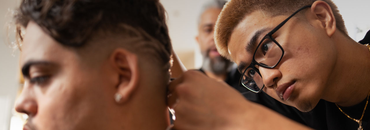 student cutting hair under teacher supervision