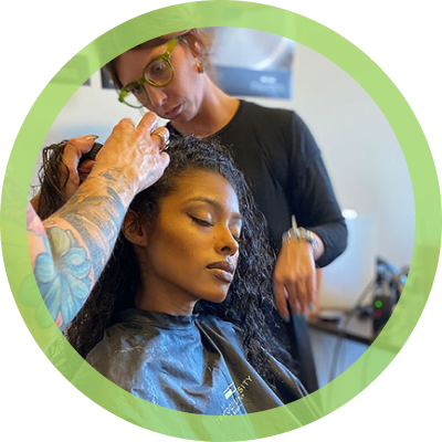student working on hair with teacher