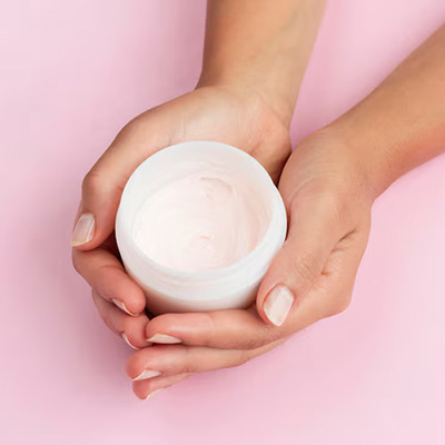 close up of hands holdings face cream box