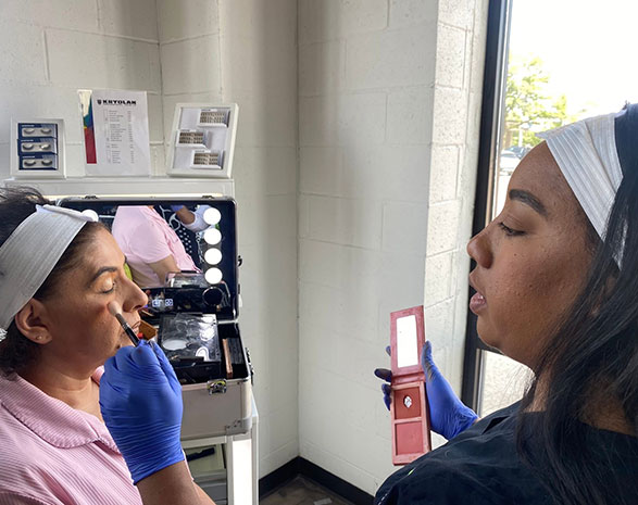 Tricoci student applying makeup at Normal, IL location